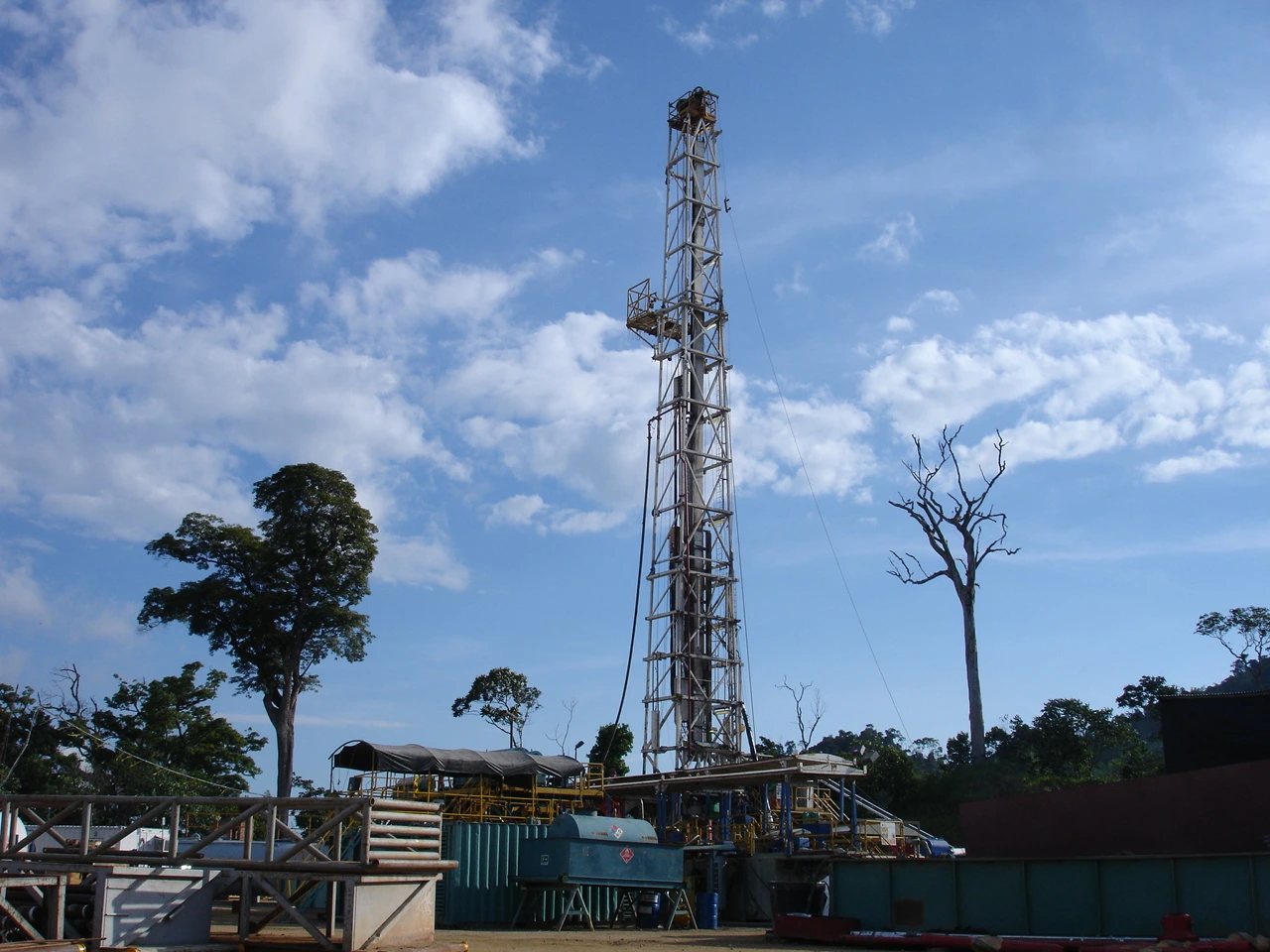 Rig de perforación petrolera con torre de perforación y equipos auxiliares en operación