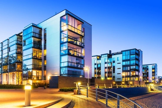 Complejo de edificios corporativos modernos con sistemas de iluminación inteligente y gestión integral de instalaciones durante horario nocturno